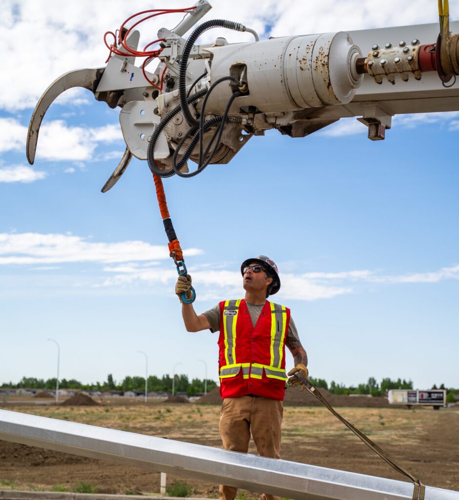 Lifting a light standard on an electrical contracting job site in Lethbridge