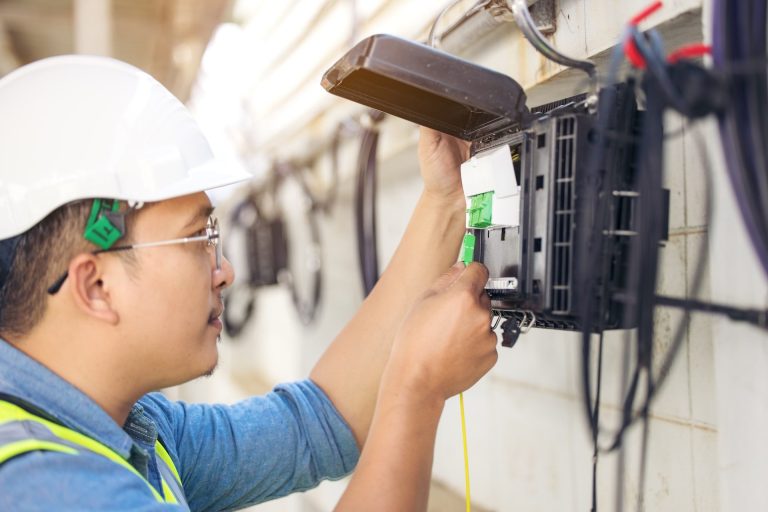 Professional inspecting an electrical panel for warning signs of a fault